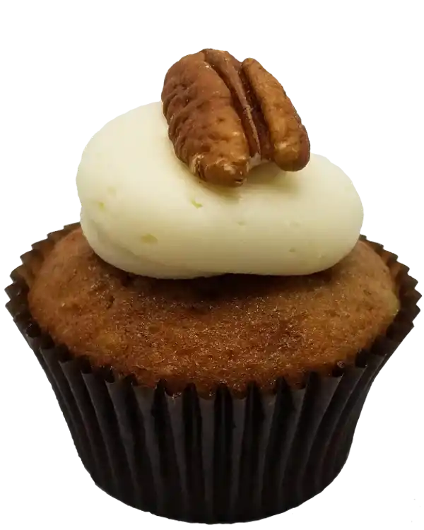 Classic US southern banana, pineapple, and pecan cupcake with cream cheese frosting, topped with a roasted pecan.